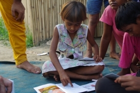 Children study English using the <i>Ollie the Elephant</i> books, at one of the slums in India where Charity United's educational programs are in operation.