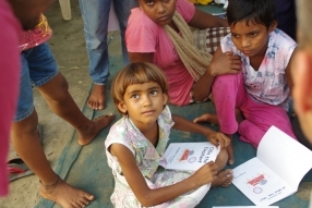 Children study English using the <i>Ollie the Elephant</i> books, at one of the slums in India where Charity United's educational programs are in operation.