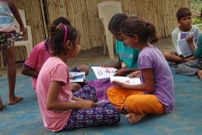 Children study English using the <i>Ollie the Elephant</i> books, at one of the slums in India where Charity United's educational programs are in operation.