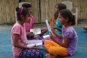 Children study English using the <i>Ollie the Elephant</i> books, at one of the slums in India where Charity United's educational programs are in operation.
